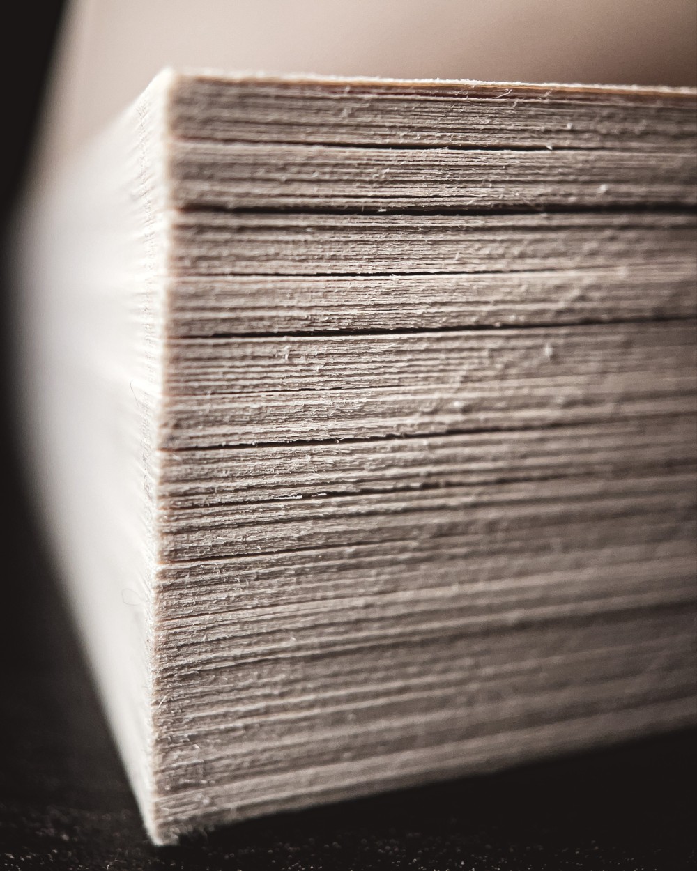 Macro photo of the corner of a stack of book with a black background.