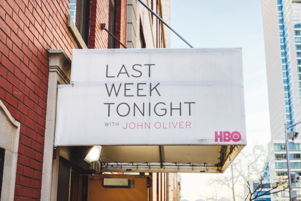 A sign attached to a brick building that reads “Last Week Tonight with John Oliver”